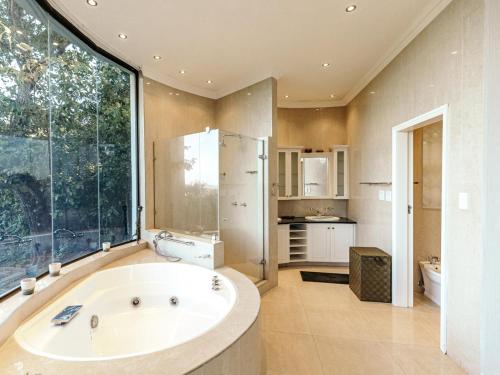 a large bathroom with a tub and a large window at Villa Aurora in Margate