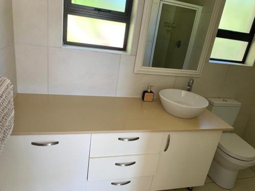 a bathroom with a sink and a toilet and a mirror at Villa Ti Amo Flat in Ramsgate