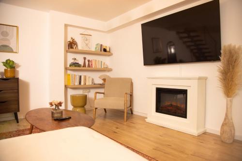 a living room with a fireplace and a tv on the wall at Gemütliches Apartment mit Garten nahe Köln in Frechen