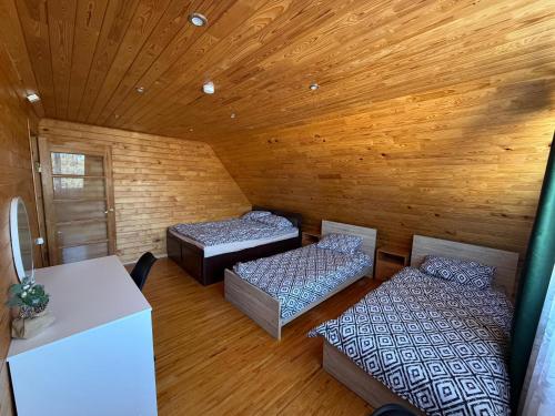 a room with two beds in a wooden cabin at Junkuri Holiday House 9 Beds up to 20 Guests in Jeroškina