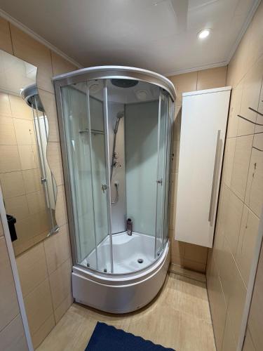 a shower with a glass enclosure in a bathroom at Junkuri Holiday House 9 Beds up to 20 Guests in Jeroškina