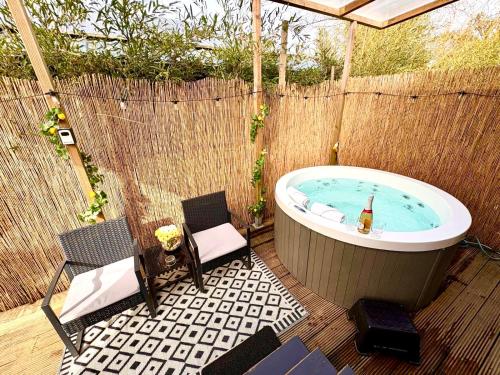 a backyard with a jacuzzi tub and chairs at Cozy tiny house with jacuzzi , garden and free parking near Amsterdam in Vijfhuizen