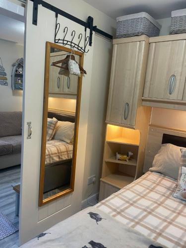 a bedroom with two beds and a mirror at Field View 162a fifth Ave in Bridlington