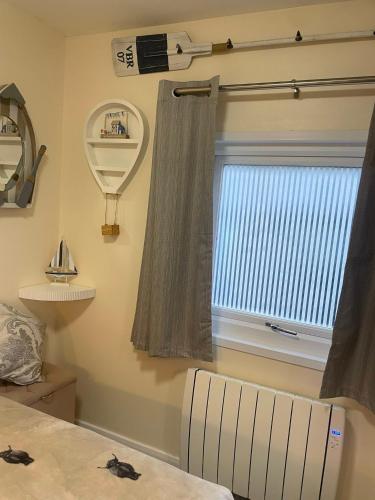 a room with a window with a curtain and a chair at Field View 162a fifth Ave in Bridlington