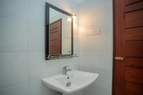 a white bathroom with a sink and a mirror at Serene Vista Villa, formerly Bungalows in Hikkaduwa