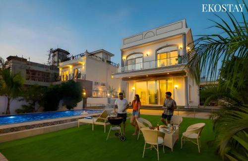 a group of people standing in front of a house at Ekostay Cliffside Villa I Mountain View in Lonavala