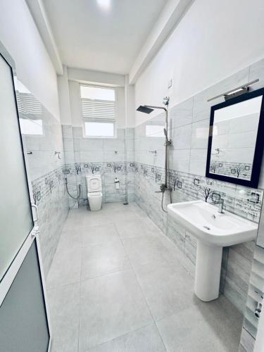 a white bathroom with a sink and a toilet at GreenKey Hotel & Resturent in Tanamalwila