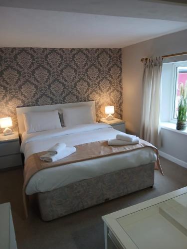 a bedroom with a bed with two towels on it at The Cross Oak Inn in Blackwood