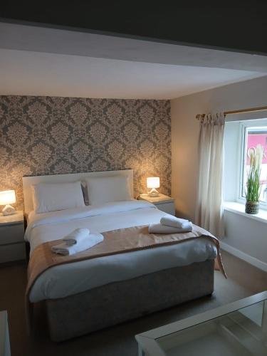 a bedroom with a bed with two towels on it at The Cross Oak Inn in Blackwood