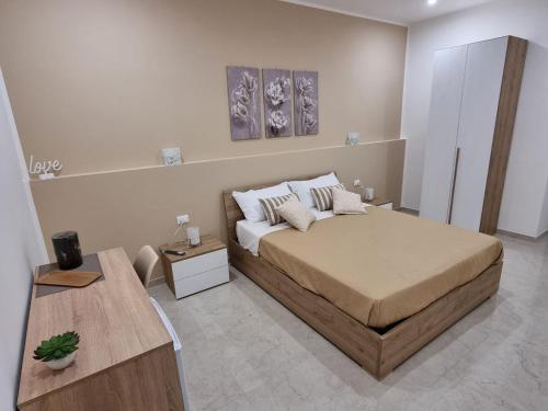 a bedroom with a large bed and a table at ASTRA Guest House in Taranto