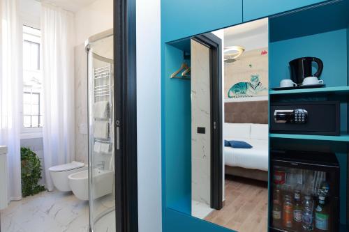 two pictures of a bathroom with a refrigerator at Hotel Sanpi Milano in Milan