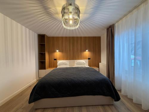 a bedroom with a large bed and a chandelier at Shiro Lodge in Predeal