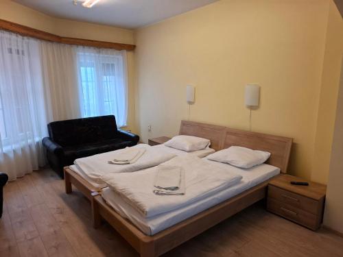a bedroom with a bed and a chair in it at Simon-Dach-Haus in Klaipėda