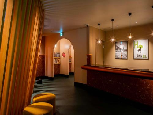 a restaurant with a bar with yellow stools at Hotel Espacio 山口 -ADULT ONLY- in Yamaguchi