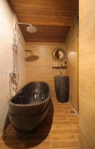 a bathroom with a large black tub and a sink at Tri Datu Palace in Saba