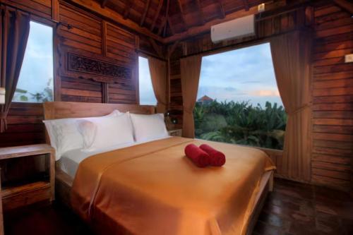 a bedroom with a bed with two red pillows on it at Tri Datu Palace in Saba