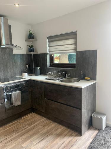 a kitchen with a sink and a counter top at The Little Red lion in Thorpe