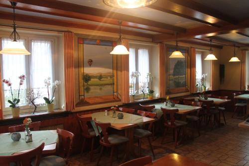 a dining room with tables and chairs and windows at Gasthaus Zur Sonne in Freiburg im Breisgau