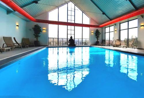 a large swimming pool with a person sitting in the middle at Azur en Ardenne in Durbuy