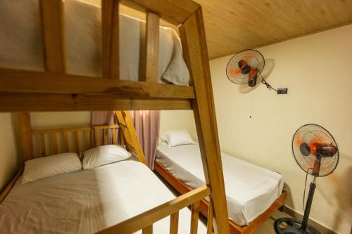 a bunk bed room with two bunk beds and a fan at Cabaña Polo in Concepción de La Vega