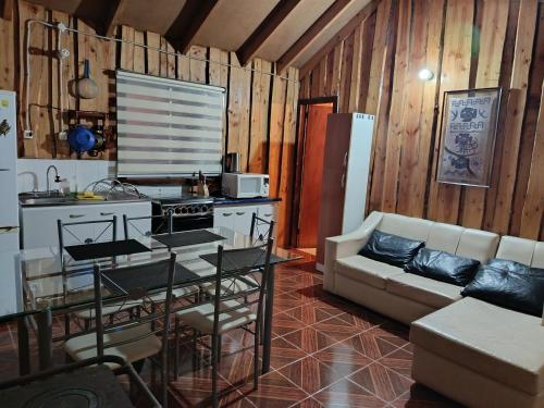 a living room with a couch and a table at cabaña vale in Coñaripe