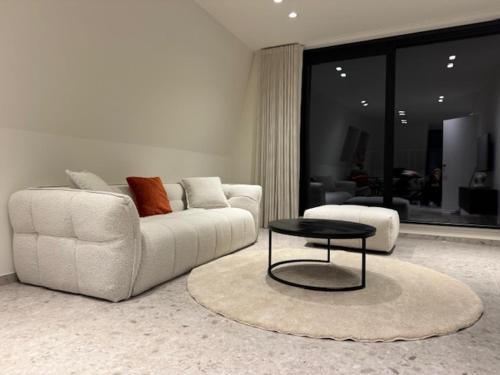 a living room with a white couch and a table at The Corner -FRANS in Beernem