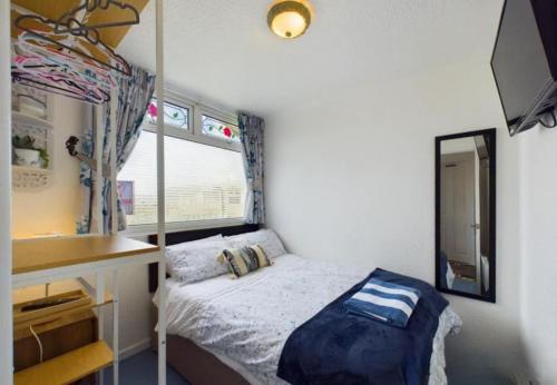 a small bedroom with a bed and a mirror at Sea Breeze Holiday Chalet in Bridlington