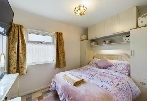 a bedroom with a bed and a window at Sea Breeze Holiday Chalet in Bridlington