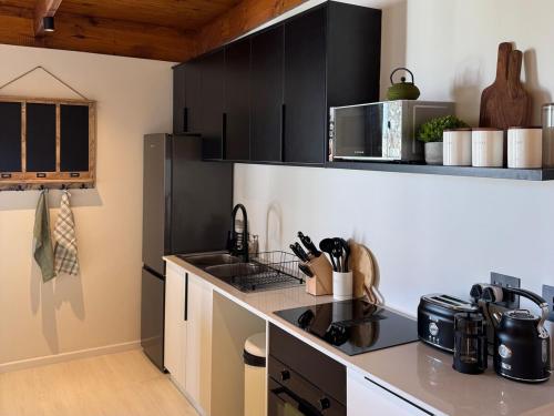 una cucina con mobili neri e un piano di lavoro di 42 on Kavango a Swakopmund