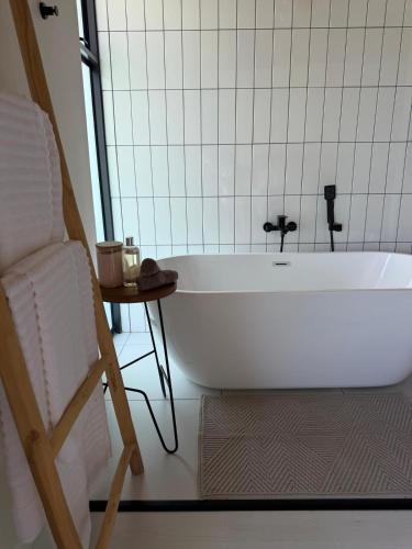 una vasca da bagno bianca in un bagno con una sedia di 42 on Kavango a Swakopmund