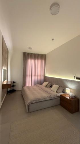 a bedroom with a large bed and a window at Al Azaiba apartment in Muscat