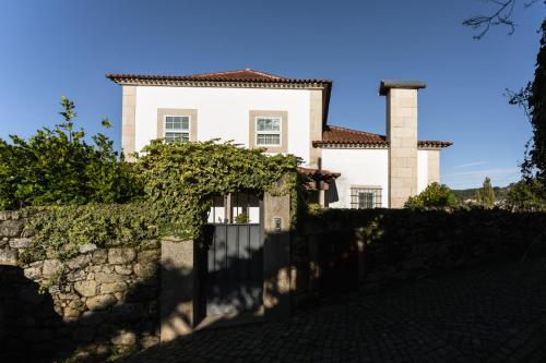 a house with a stone fence in front of it at Casas da Memória in Tarouca