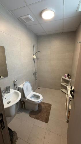 a bathroom with a toilet and a sink at Al Azaiba apartment in Muscat