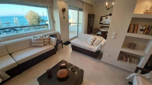 a living room with a couch and a large window at Villa Veranda in Neoi Epivates