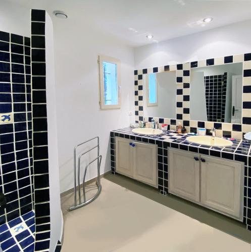 a bathroom with two sinks and black and white tiles at Luxury Villa, Infinity Pool, Beach 5 min in Ramatuelle