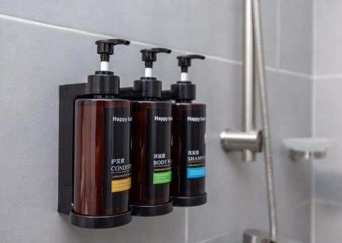 a group of three shampoo bottles on a shelf in a bathroom at Layla by J&J At J Towers Residences It's just right next to SM JMall in Mandaue City