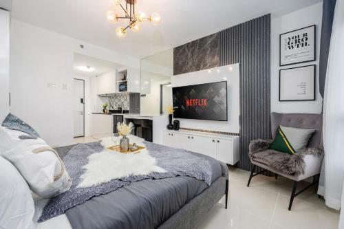 a bedroom with a bed and a tv and a chair at Layla by J&J At J Towers Residences It's just right next to SM JMall in Mandaue City