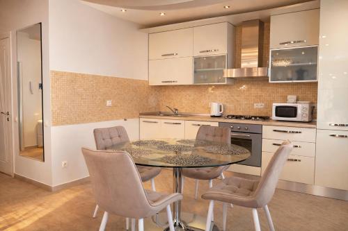 una cucina con un tavolo e sedie in una stanza di Premium City Residence a Chişinău