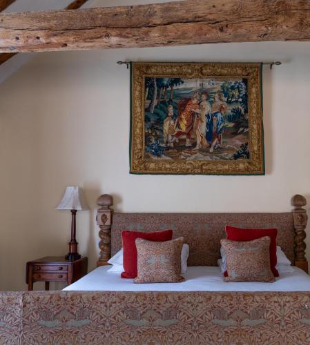 a tapestry hangs above a bed in a bedroom at Hintlesham Hall Hotel in Ipswich