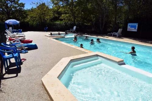 a group of people swimming in a swimming pool at ZEcamping 3 pataugeoire animations locatif TV BBQ 24m2 4 pers in La Souterraine