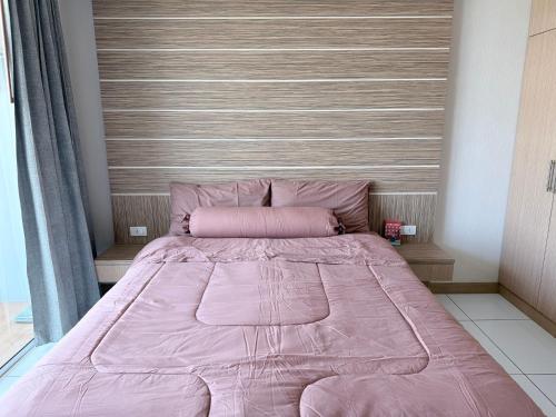 a pink bed in a bedroom with a headboard at Whale Marina Condo in Na Jomtien