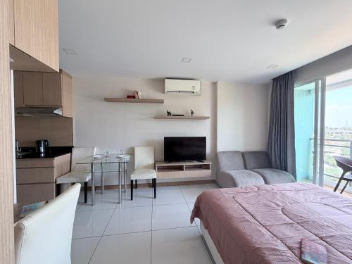 a bedroom with a bed and a kitchen with a table at Whale Marina Condo in Na Jomtien