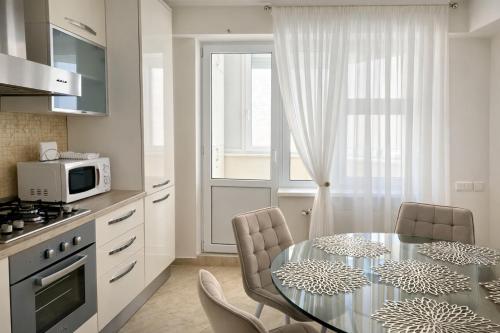 una cucina con tavolo con sedie e forno a microonde di Premium City Residence a Chişinău