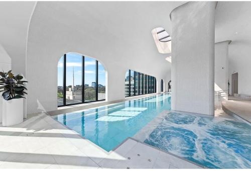 a large swimming pool with blue water in a building at Boutique 1B2B HighRise Condo in CBD in Melbourne