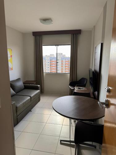 a living room with a couch and a table at Boulevard suite hotel apartamento 434 in Caldas Novas
