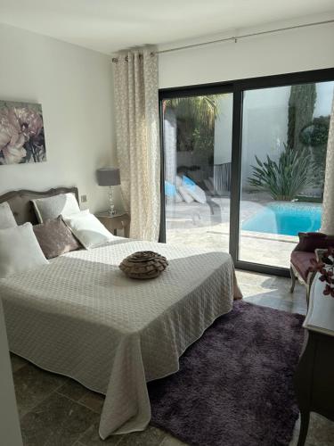 a bedroom with a large bed and a swimming pool at Superbe villa golfe st Tropez in Sainte-Maxime