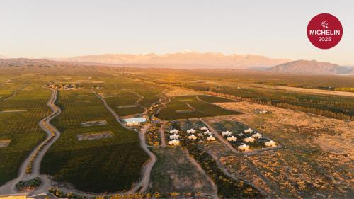 an aerial view of a farm with mountains in the background at Chozos Resort in Agrelo