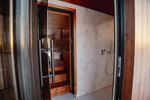 a bathroom with a walk in shower and a glass door at Luxury Resort Ehametsa in Vaibla