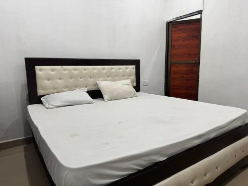 a bed with two pillows on it in a bedroom at HOTEL INDRANEEL Hanuman Garhi in Ayodhya
