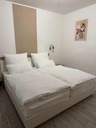 a white bed with white sheets and pillows at Lingen Stay in Lingen